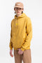 Männer Model trägt den Rotholz Retro Logo Hoodie aus Bio-Baumwolle in Senfgelb