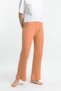 Das Frauen Model trägt die gerippte Rotholz Hose aus Bio Baumwolle in Apricot