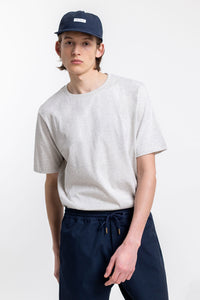 Das Männer Model trägt das Rotholz Logo T-Shirt aus Bio-Baumwolle in Grau